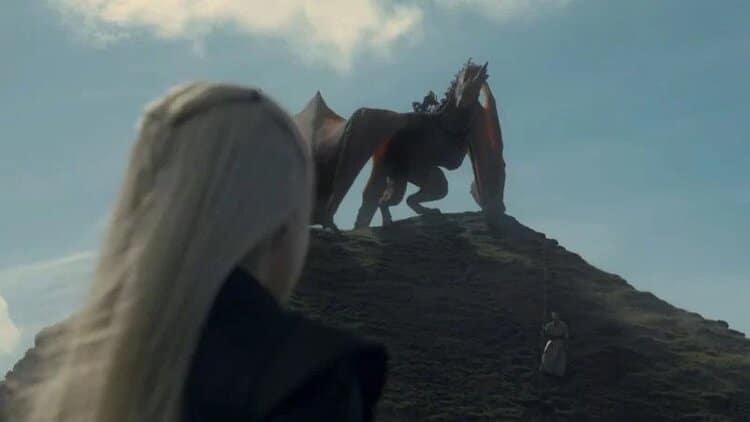 Princess Rhaenyra’s dragon, Syrax, stands on the top of a hill with Rhaenyra looking up to her.