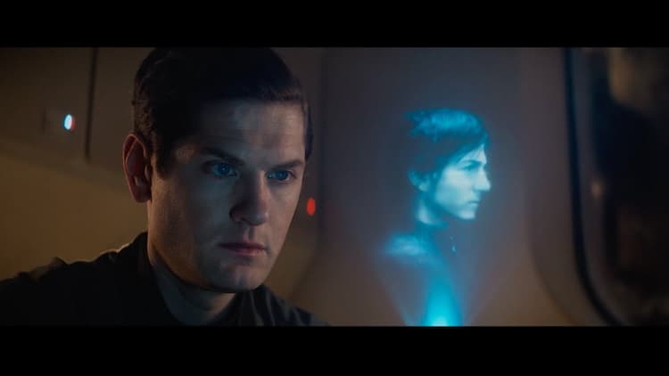 A closeup of Syril's face as he stares at the hologram of Cassian, his face expressionless.