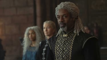 A closeup of Vaemond as he stands in the throne room of the Red Keep making his claim to the Driftmark throne. Rhaenys and Baela stand nearby.