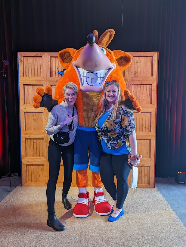 Erika and Michelle pose with Crash Bandicoot.