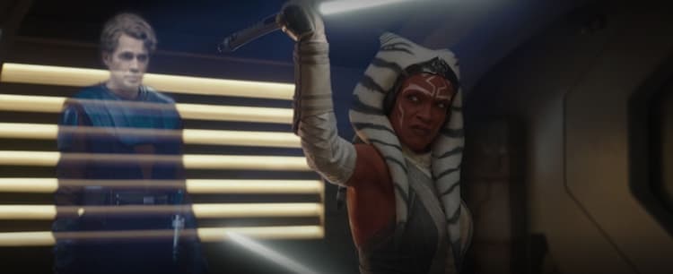 Ahsoka practices lightsaber forms in front of a holographic image of Anakin Skywalker