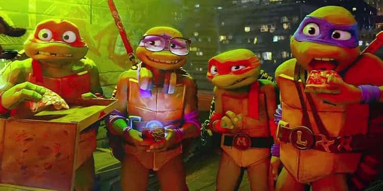 Raphael, Donatello, Michelangelo, and Leonardo are standing on a rooftop, eating pizza. Donatello is on his phone, and all of them look confused