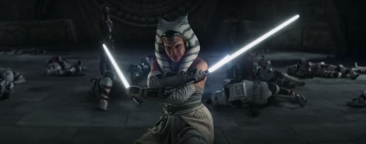 Ahsoka Tano dressed in white dual wields white lightsabers standing amongst numerous fallen troopers. Sabine and Ezra stand in the background