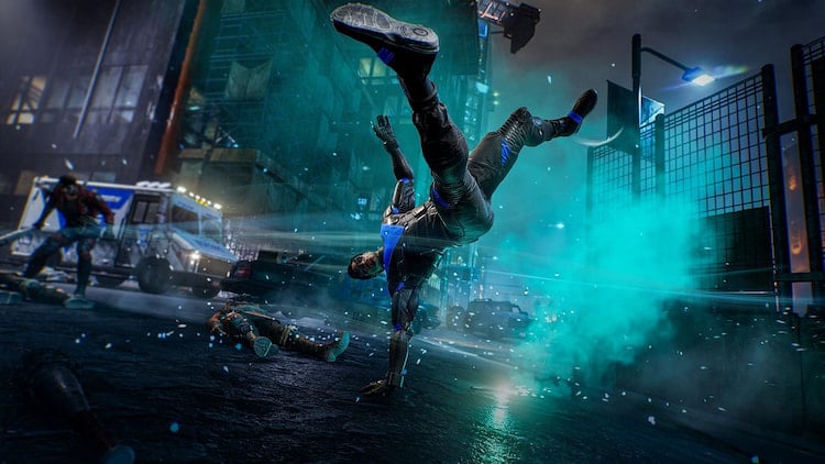 A costumed vigilante acrobatically kicks out an enemies in a glow of blue light