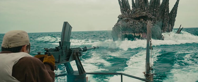 Godzilla swimming after a boat with a man on a mounted machine gun