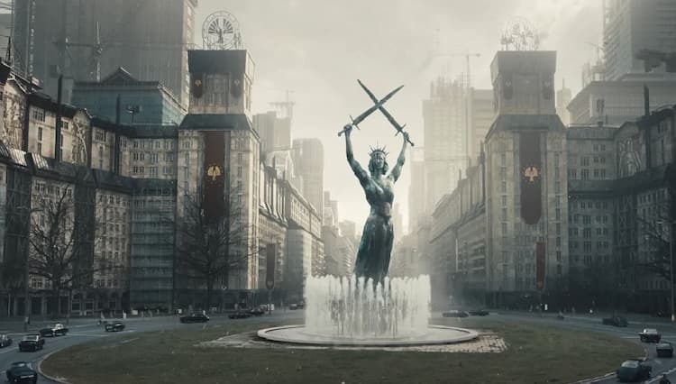 A statue of a woman holding two swords is in the middle of a roundabout. Fountains surround the base of the statue. Cars are driving around the statue and various buildings can be seen.