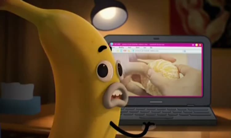 A banana boy nervously turns around to see a blue cat has walked into the room, catching him watching an orange being peeled on his laptop