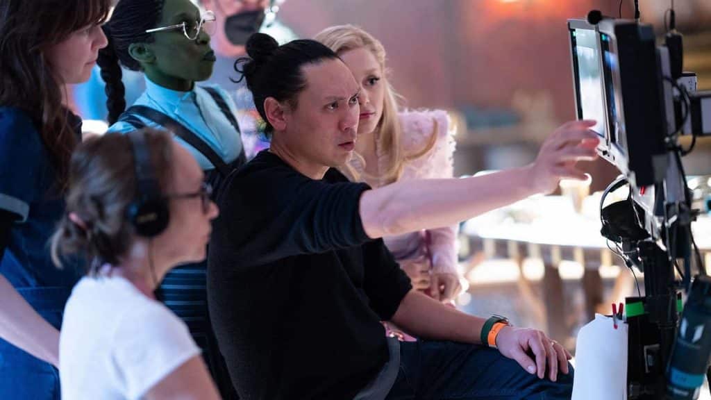 An image of Jon M. Chu hard at work directing the cast behind the scenes.