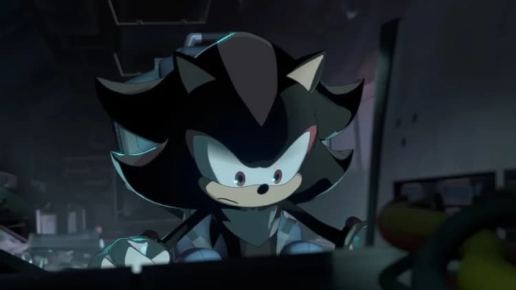 Shadow is sitting in a spaceship and flying towards the ARK. He has a shocked look on his face as he looks down. Various dials and controls cover the console in front of him.